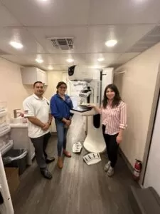 Techs in front of mammogram machine